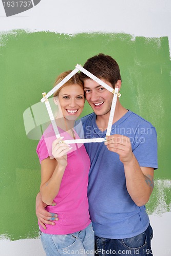 Image of happy couple paint wall at new home