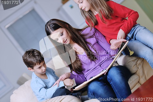 Image of young mom play with their kids at home and reading book