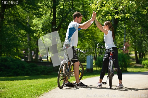 Image of Happy couple ridine bicycle outdoors