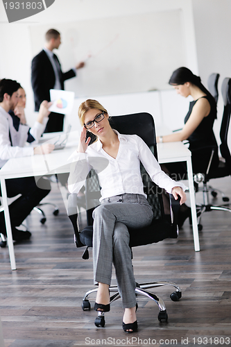 Image of business woman with her staff in background