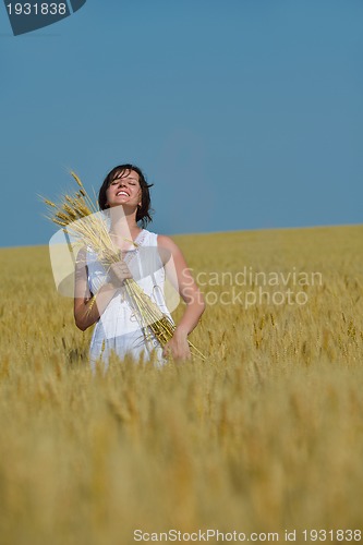 Image of young woman in wheat field at summer