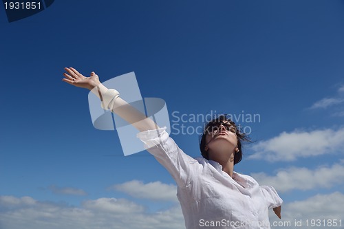 Image of happy young woman with spreading arms to sky