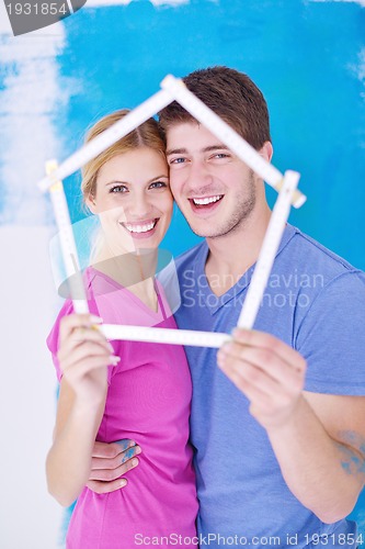 Image of happy couple paint wall at new home