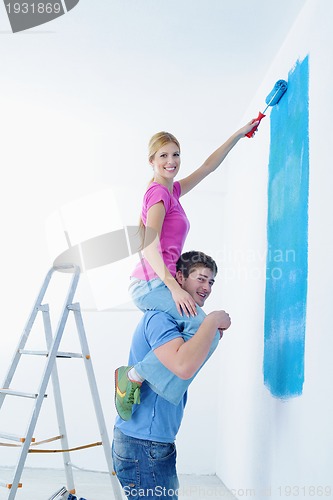 Image of happy couple paint wall at new home