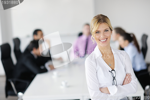 Image of business woman standing with her staff in background