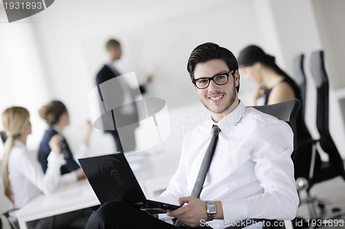 Image of handsome young business man with colleagues in background