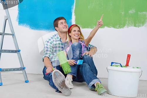 Image of happy young cople relaxing after painting in new home