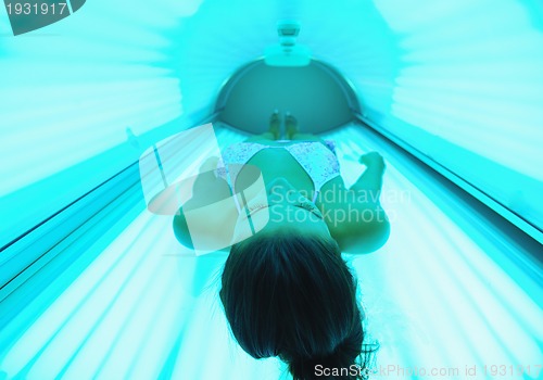 Image of Beautiful young woman tanning in solarium