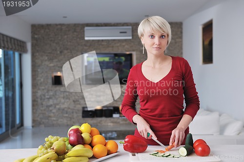 Image of happy  beautiful blonde  woman prepare food in  the kitchen