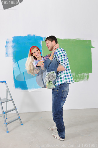 Image of happy couple paint wall at new home