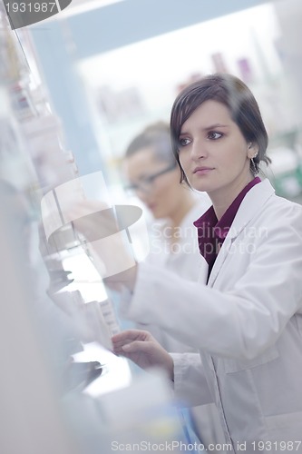 Image of pharmacist chemist woman standing in pharmacy drugstore