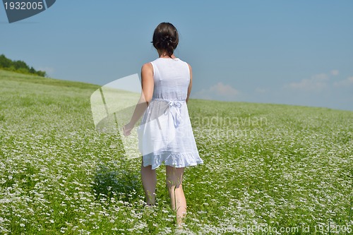 Image of Young happy woman in green field