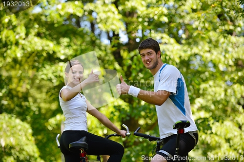 Image of Happy couple ridine bicycle outdoors