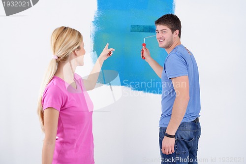 Image of happy couple paint wall at new home