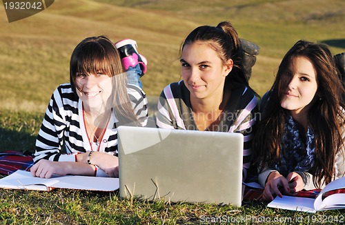 Image of group of teens working on laptop outdoor