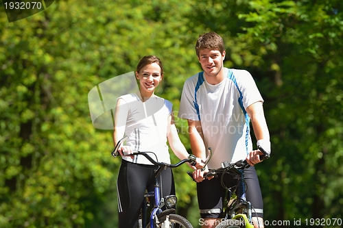 Image of Happy couple ridine bicycle outdoors
