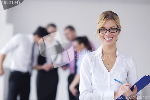 Image of business woman standing with her staff in background
