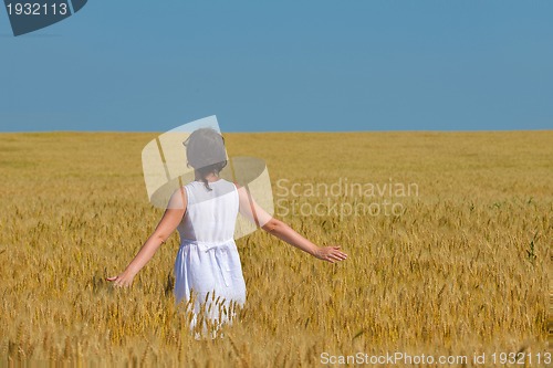 Image of young woman in wheat field at summer