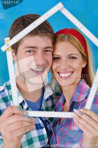 Image of happy couple paint wall at new home