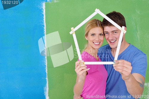 Image of happy couple paint wall at new home