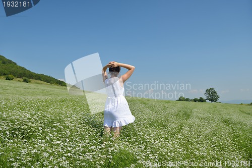 Image of Young happy woman in green field