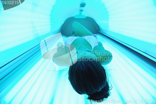 Image of Beautiful young woman tanning in solarium