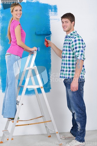 Image of happy couple paint wall at new home