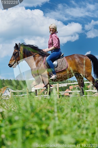 Image of happy woman  on  horse