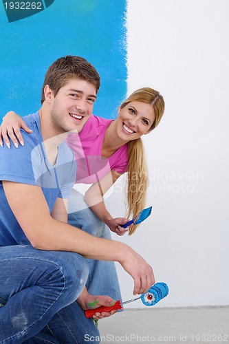 Image of happy couple paint wall at new home