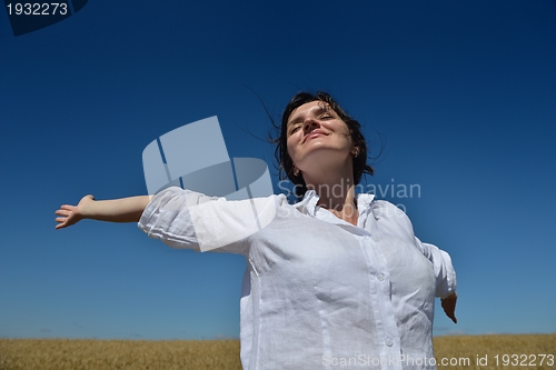 Image of young woman in wheat field at summer