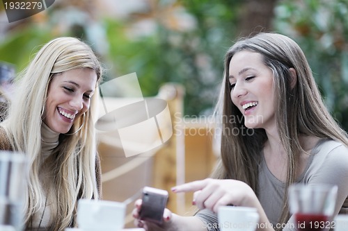 Image of cute smiling women drinking a coffee