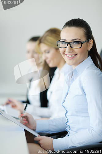 Image of business woman standing with her staff in background