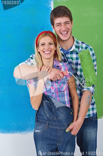 Image of happy couple paint wall at new home