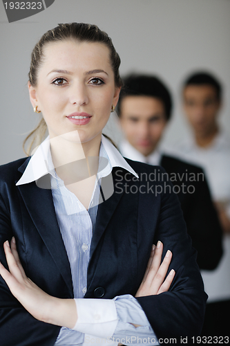 Image of business woman standing with her staff in background