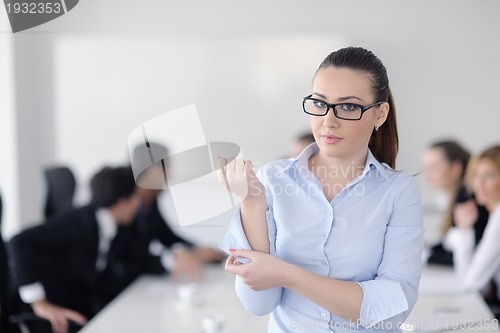 Image of business woman standing with her staff in background