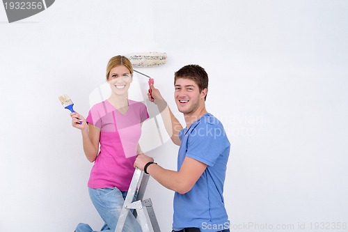 Image of happy couple paint wall at new home