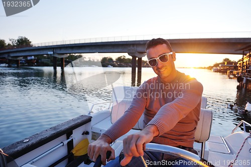 Image of portrait of happy young man on boat