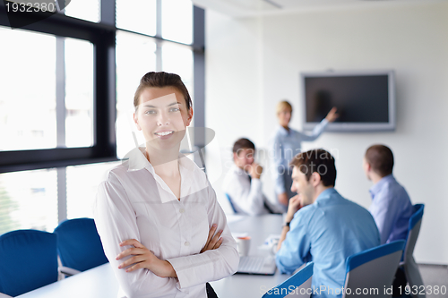 Image of business woman with her staff in background at office