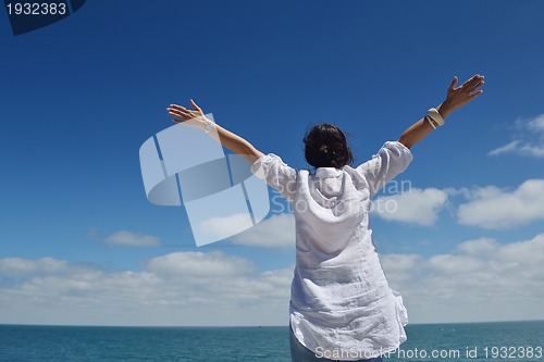 Image of happy young woman with spreading arms to sky