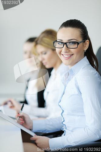 Image of business woman standing with her staff in background