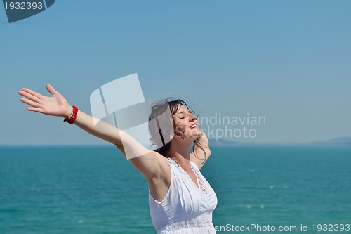 Image of happy young woman with spreading arms to sky