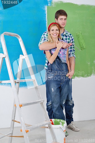 Image of happy couple paint wall at new home