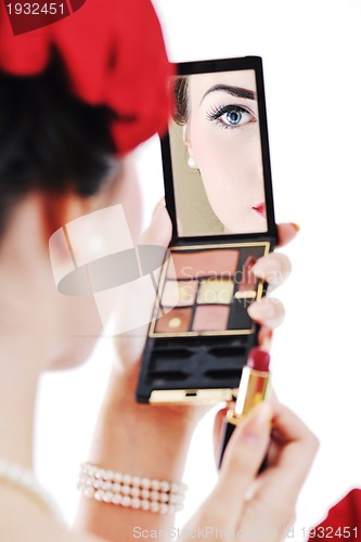 Image of beautiful young woman applying makeup