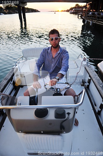 Image of portrait of happy young man on boat