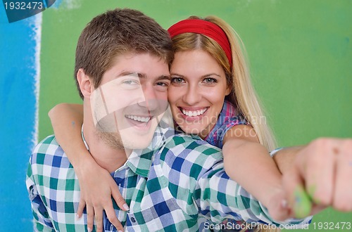 Image of happy couple paint wall at new home