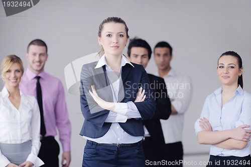 Image of business woman standing with her staff in background