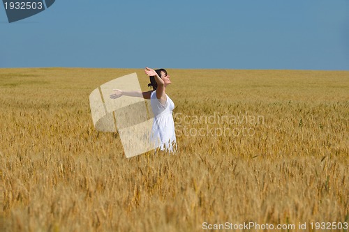 Image of young woman in wheat field at summer