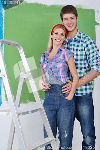 Image of happy couple paint wall at new home