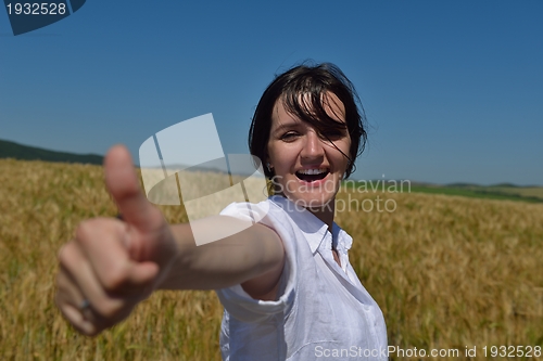Image of young woman in wheat field at summer