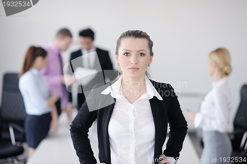 Image of business woman standing with her staff in background